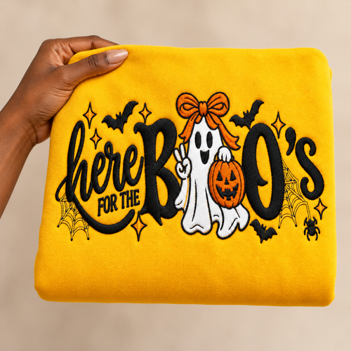 Black woman's hand holding the gold Here for the Boo's embroidered sweatshirt